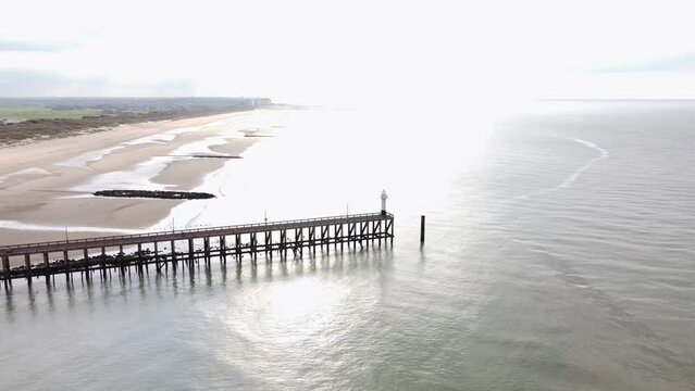 Aerial view of the white wooden pier in the town of Blankenberge on the Atlantic coast of Belgium during the morning sun