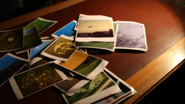 Colored UFO pictures and symbols in fields, on table in lamplight