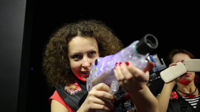 Young woman is holding plastic weapon for laser tag and targeting.