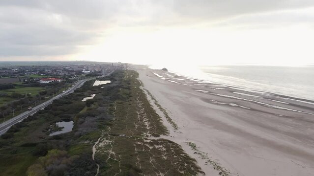 Aerial view of sunset, sandy beaches and endless ocean near Blankenberge, region of Flanders, Belgium. Evening light