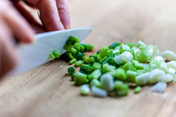 person cutting a green onion
