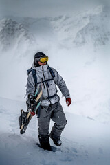 Fototapeta na wymiar Snowboarder beim Aufstieg zum Gipfel