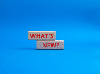 What is new symbol. Concept word What is new on wooden blocks. Beautiful blue background. Business and What is new concept. Copy space