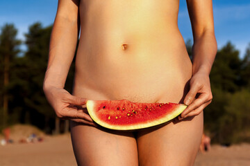 Crop photo of naturist lady posing covering watermelon naked on beach, close up. Perfect nude woman with sexy body, no clothes. Nudism naturism lifestyle concept, clothing optional. Copy ad text space