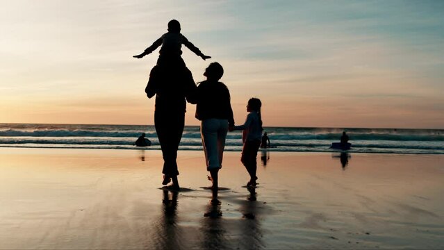 Back, piggyback and silhouette of family on beach, walking together for travel, holiday or vacation. Children, mother and father by water, ocean or sea for love, adventure or bonding at sunset