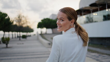 Relaxed woman enjoy promenade at evening city close up. Lady walking modern town