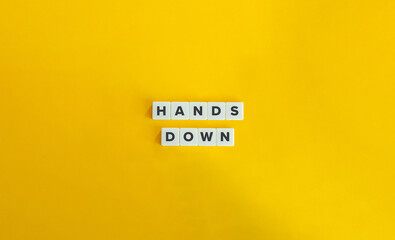 Hands Down Idiom. Text on Block Letter Tiles on Yellow Background.