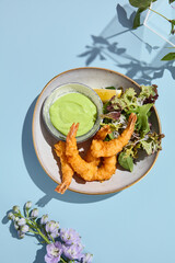 Artistic tempura shrimp with wasabi sauce, accompanied by summer blooms and soft pastel tones