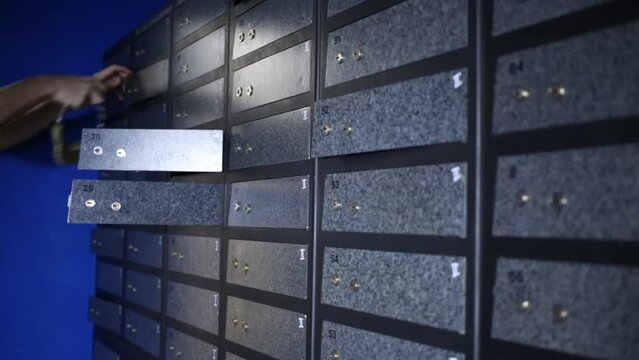 Male hand opening small boxes in closet using keychain 