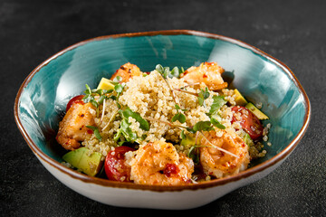 Shrimp and quinoa salad with avocado and tomatoes, served in a turquoise bowl