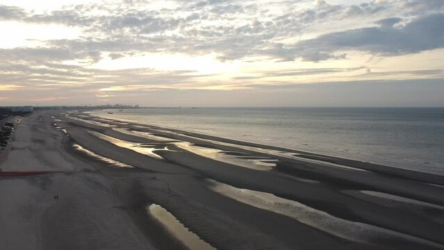 Aerial view of sunset, sandy beaches and endless ocean near Dunkirk, France. Plage de Zuydcoote in the evening light