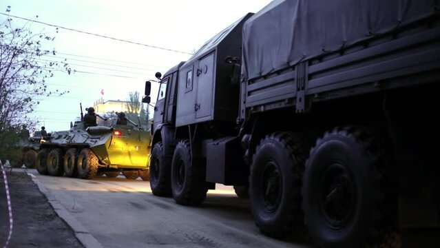 Soldiers with rocket launchers on shoulders riding on armored vehicles
