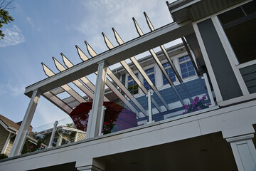 Modern Pergola Detail with Floral Balcony Against Blue Sky