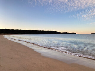 Sunset at the beach. Dawn on the beach. Waves curling on the shore. Ocean view at low tide.