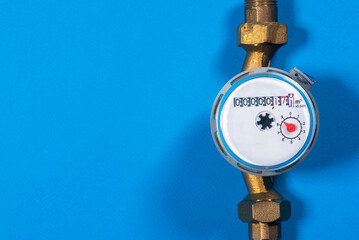 Water meter on the blue flat lay top view background with copy space. Water consumption concept.
