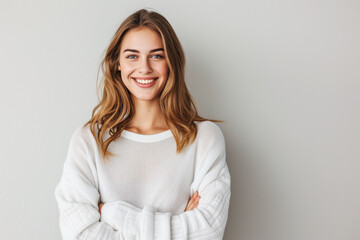 Fototapeta premium smiling woman in white sweater with arms folded