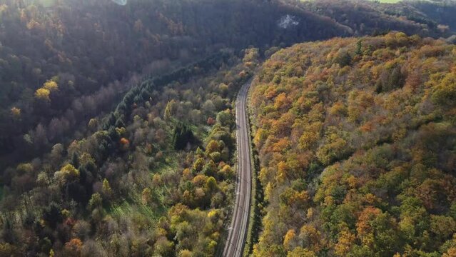 Aerial view of the railway network cutting through an autumn-colored forest near the town of Dinant in the province of Namur in the French part of the Belgian country