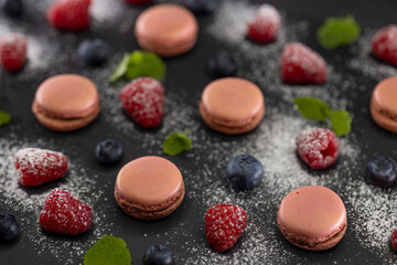 macaroons of different colors on a black background