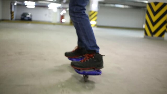 Closeup of boy feet riding on waveboard in underground parking
