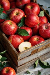 Wooden box full of fresh ripe apples and cut half pieces