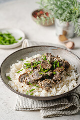 Risotto with mushrooms and herbs on white marble background.