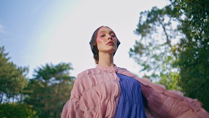 Sensual model posing woods landscape moving hands with airy dress close up.