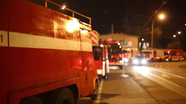 Fire trucks parked on the side of the road with tram tracks at night