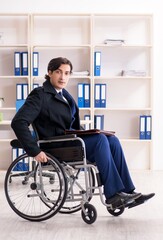 Young male employee in wheelchair working in the office