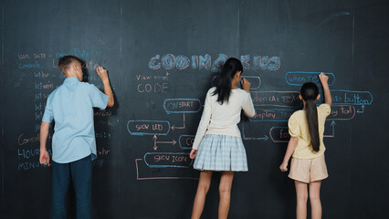 Multicultural highschool student writing engineering code or prompts on blackboard. Diverse happy teenager using mind map to brainstorm programing system at STEM technology class. Edification.