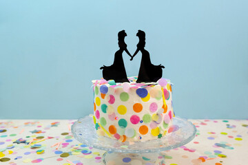 Two brides cake toppers on wedding cake with confetti. Lesbian wedding