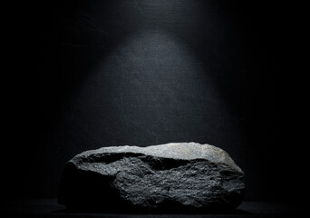 black stone with texture on a dark background for the podium