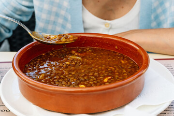 Close-up of a savory traditional lentil stew, a staple in Asturian cuisine, served in a rustic...