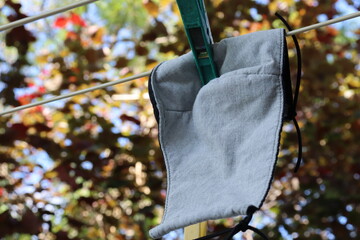 reusable cloth covid19 mask hanging on clothes line outdoors to dry after washing