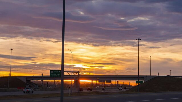 road in a city in sunrise colorful morning with beautiful cloudscape background. time lapse vehicles traveling on the road rush hours. High-way busy time. sunlight shines through the cloud's footage