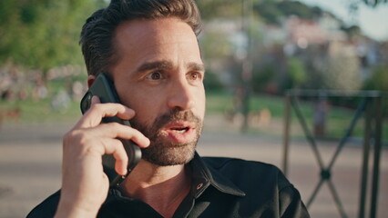 Emotional guy speaking smartphone call sunshine park closeup. Latin man calling