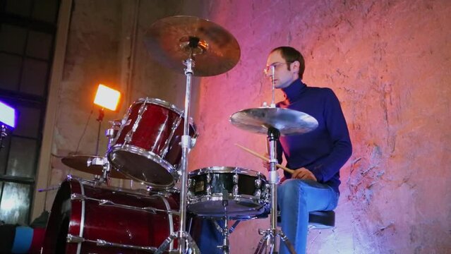 Drummer performs in studio with light equipment during survey