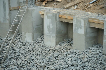 Building foundation construction. Monolithic concrete and reinforced concrete structures on the construction site. The use of metal formwork and fittings in construction.
