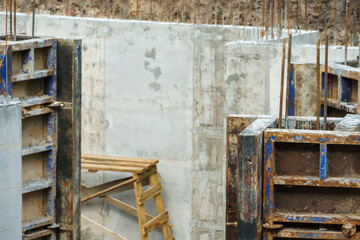 Building foundation construction. Monolithic concrete and reinforced concrete structures on the construction site. The use of metal formwork and fittings in construction.