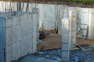 Building foundation construction. Monolithic concrete and reinforced concrete structures on the construction site. The use of metal formwork and fittings in construction.