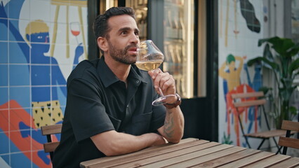 Italian tourist drinking wine glass at urban cafe closeup. Man sipping alcohol