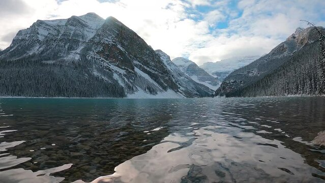 clear lake and mountains scenery in snowy winter season. Cold weather approach in north then Canada in mid-October. water surface lapping in peaceful texture with slow-moving heat float up to the air