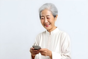 asian senior woman holding mobile phone isolated on white background - Powered by Adobe