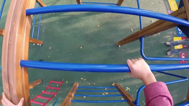 Girl climbing on ladder on children playground, First Person View