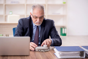 Old male employee working in the office