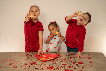 Niños felices contentos comiendo galletas que ellos mismos prepararon para compartir en san...