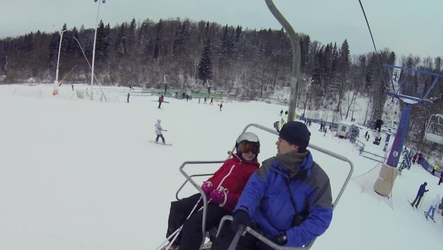 Man with daughter makes selfie on cableway in ski resort