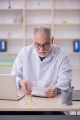 Old male doctor working in the clinic