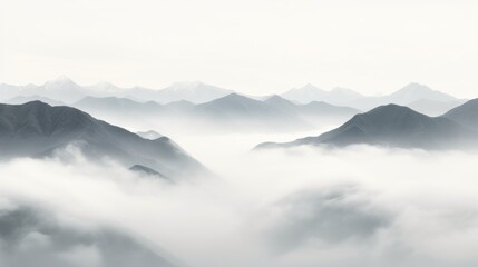  a black and white photo of a mountain range with low lying clouds in the foreground and low lying mountains in the background.