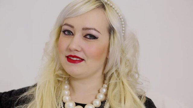 Face of blonde woman with pearl necklace and diadem