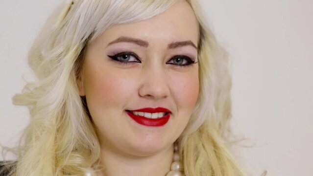 Blonde woman smiles with pearl necklace and diadem